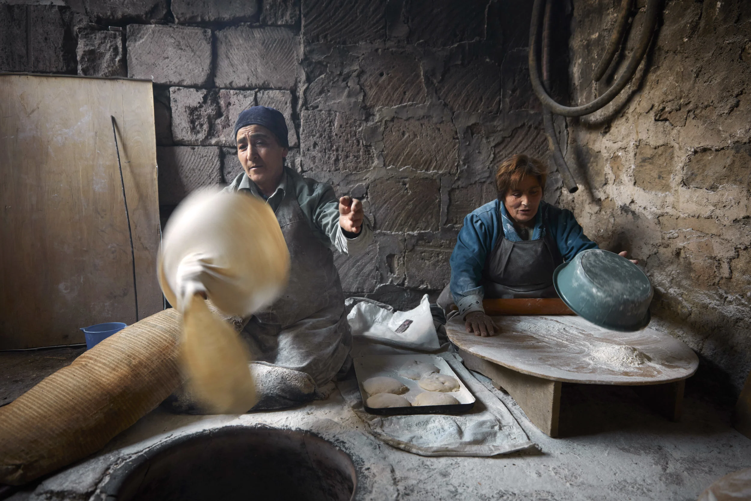 In Yeghvard, each neighbor tool on a different responsibility around the tonir: some rolled the dough, some removed it from the walks of the tonir. But the most challenging job was spinning and stretching the dough out into a thin sheet.
