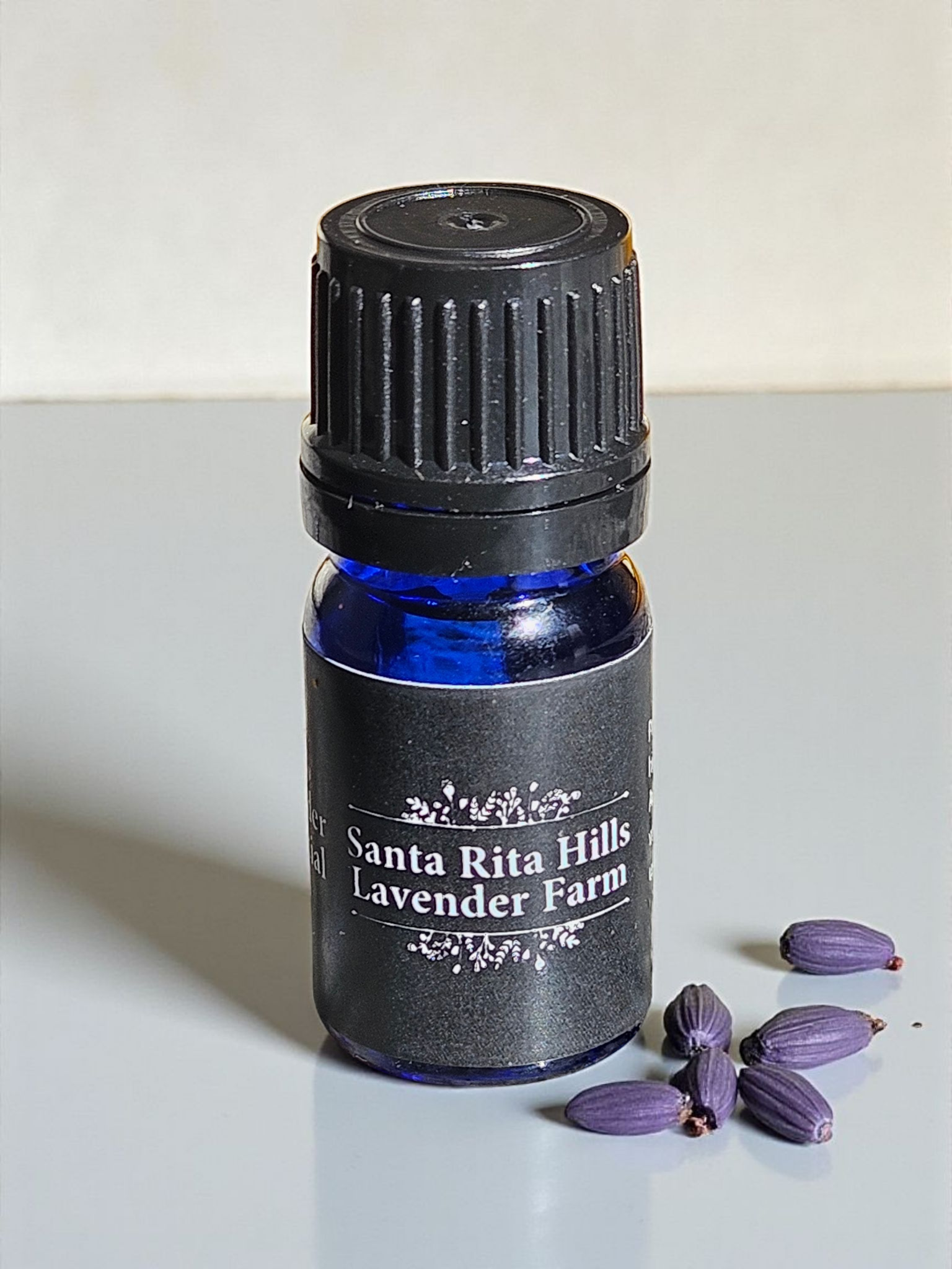 Lavender Essential oil in front of Lavender buds at Santa Rita Hills Lavender Farm in Santa Barbara County area