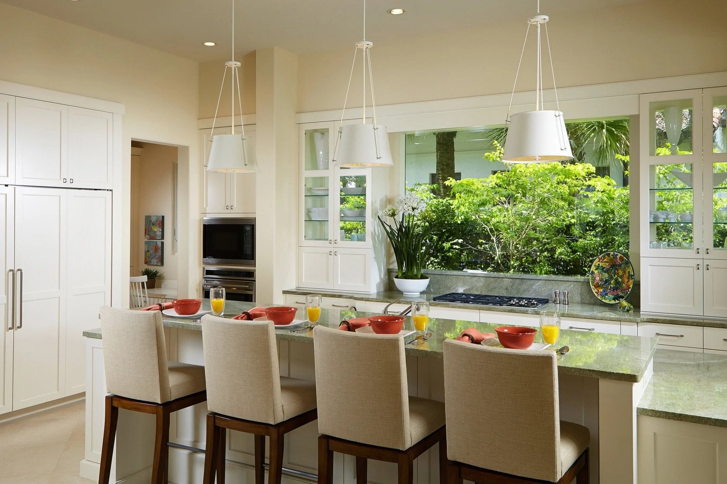 Breakfast with a view! When designing our Tropical Retreat project, we made sure the kitchen also received its own, gorgeous view. A large window and glass-backed cabinets allow morning light to pour in. What goes better with coffee than a little sun