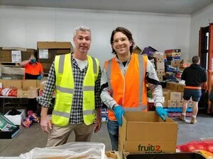 Russ Shields and Dr Sandro Demaio from VicHealth packing boxes for residents living in locked-down housing estates.