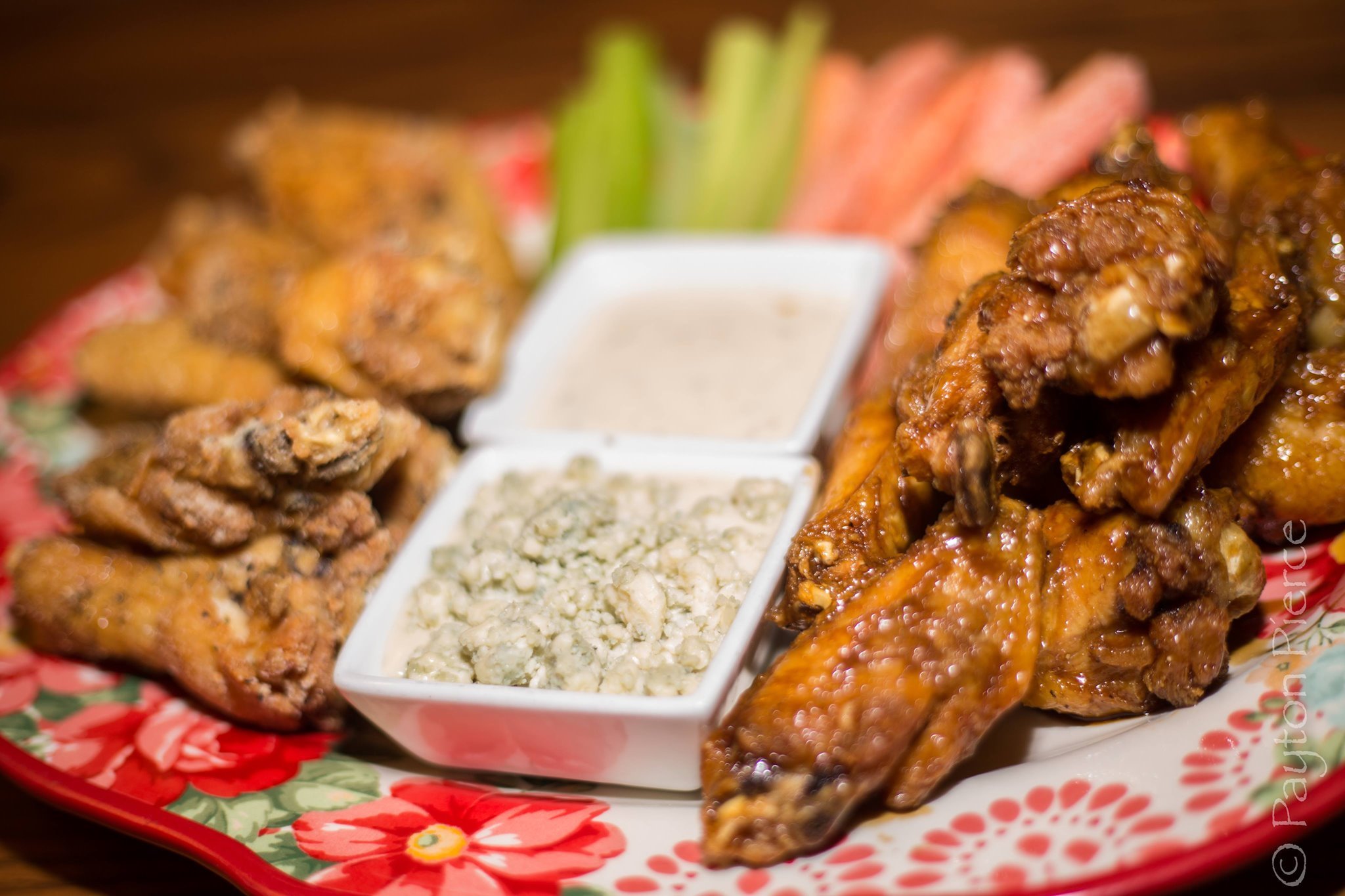 Plate with fried chicken, buffalo wings, celery sticks, blue cheese and ranch dressings, and fried catfish.
