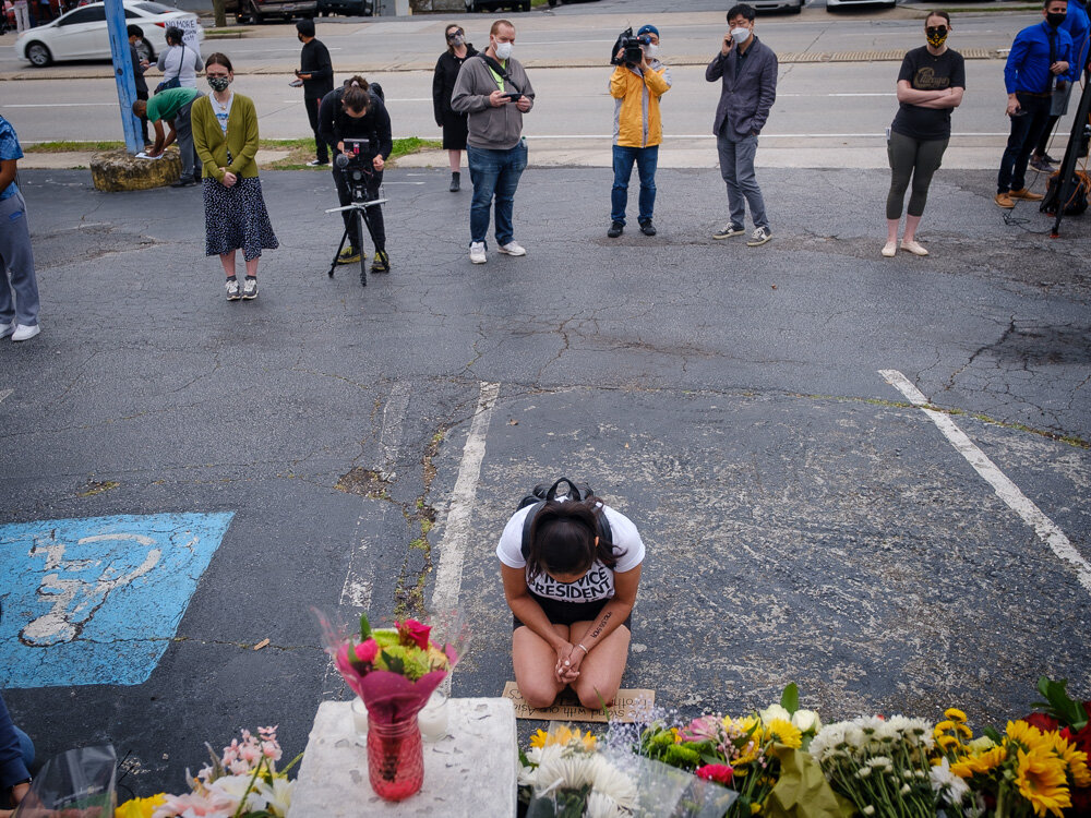  A mourner kneels in front of Gold Spa in Atlanta on March 18, 2021, two days after a gunman shot and killed eight people at three Atlanta-area spas. 