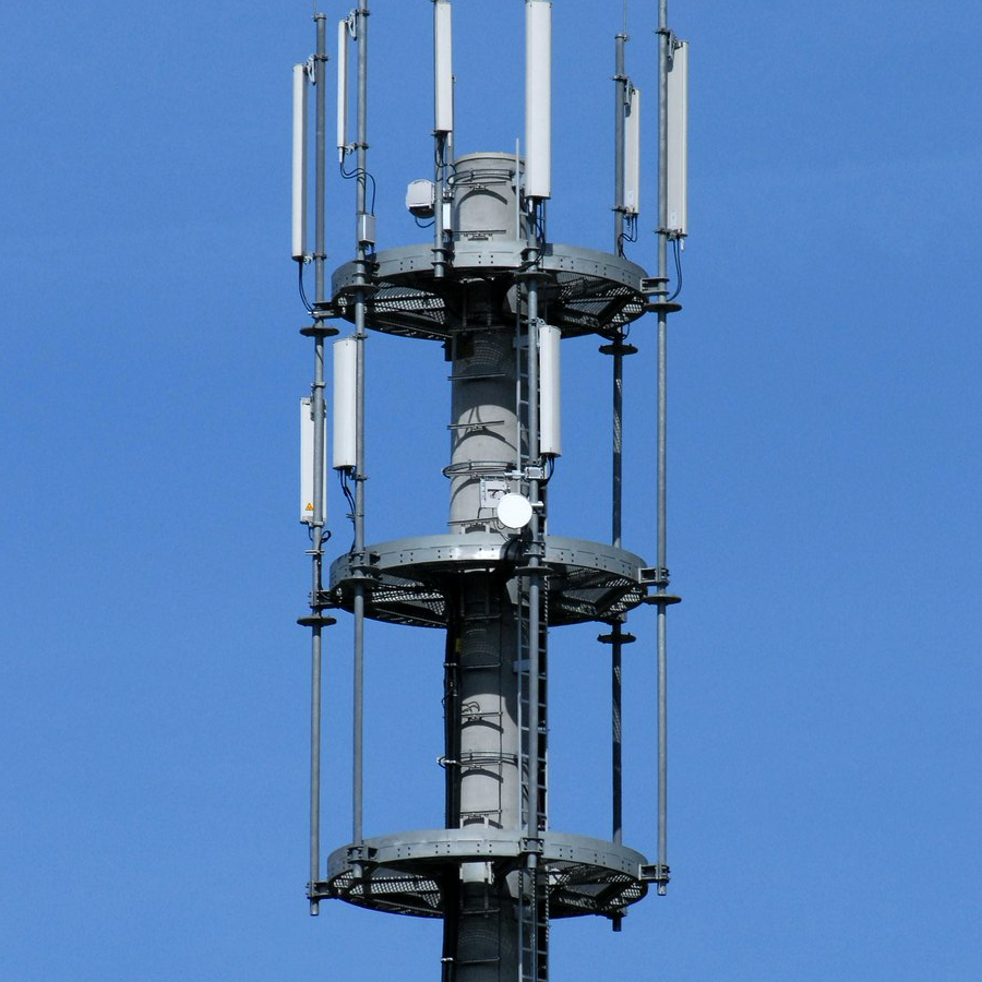 Telecoms mast with antenna arrays against a blue sky