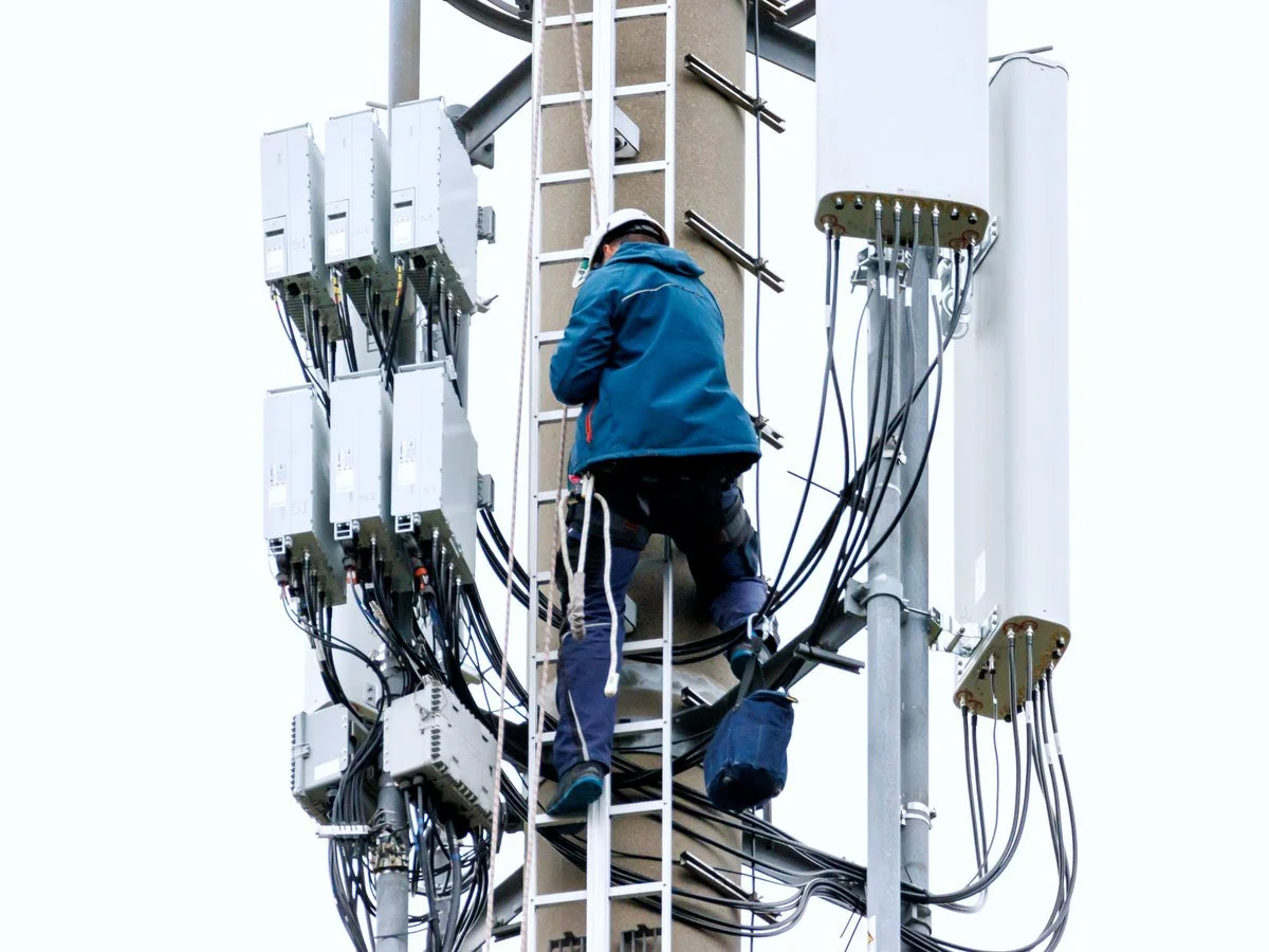 Engineer working on antennas up a radio mast