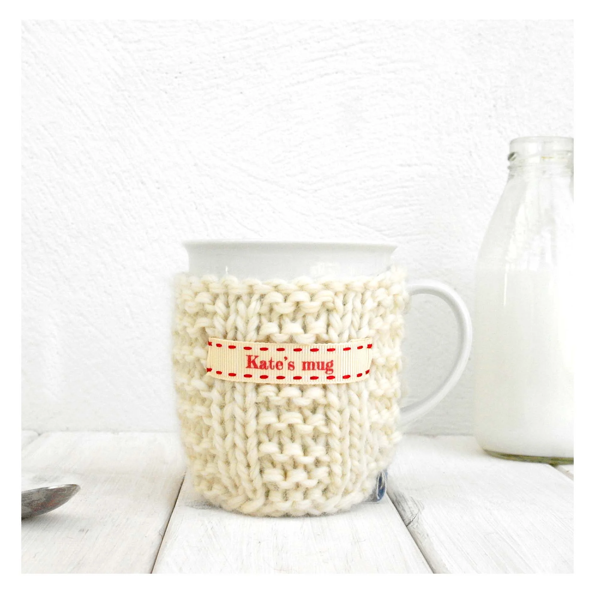 Chichimoi-Personalised-knitted-mug-cosy-handmade-in-britain-Cream-with-Red-Ribbon.jpg