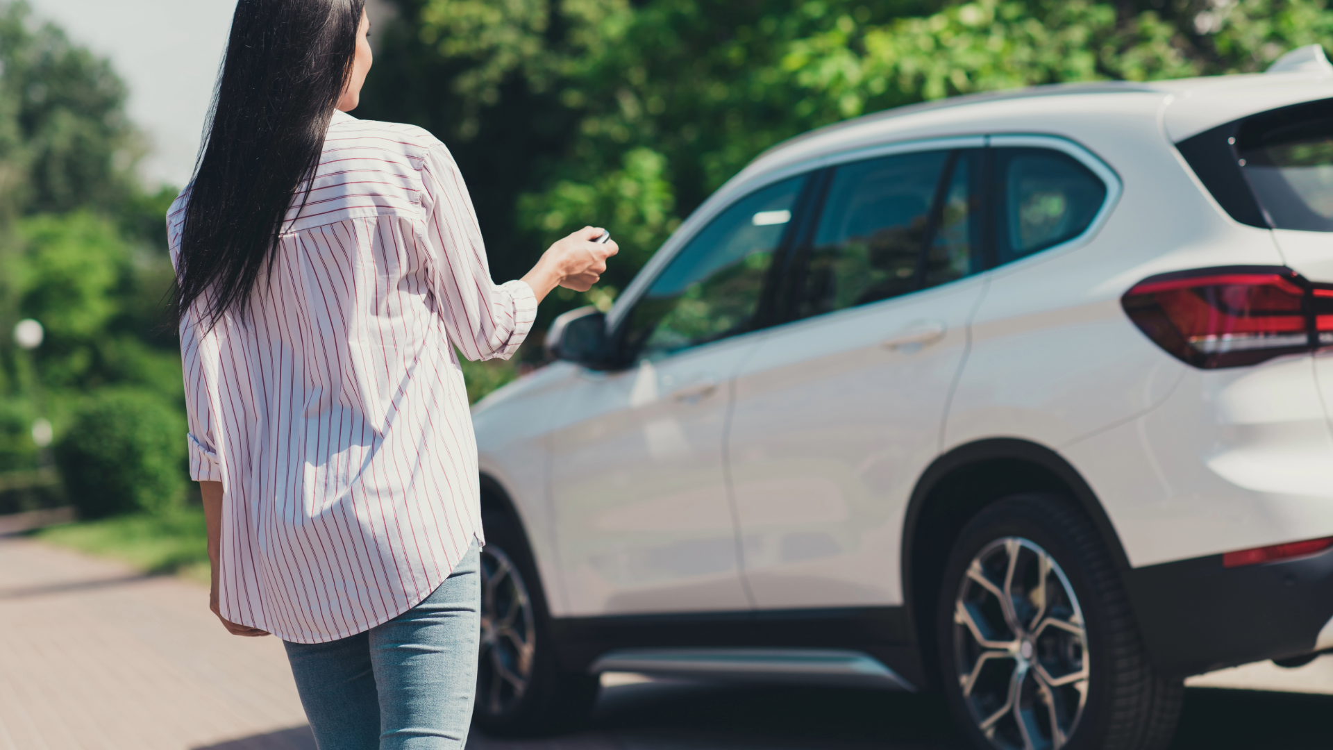 Person standing next to car with keys