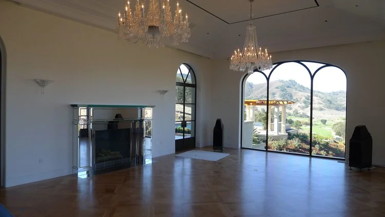 LIVING ROOM WITH BACCARAT CRYSTAL FIREPLACE SURROUND, CHANDELIERS, AND SCONCES.
