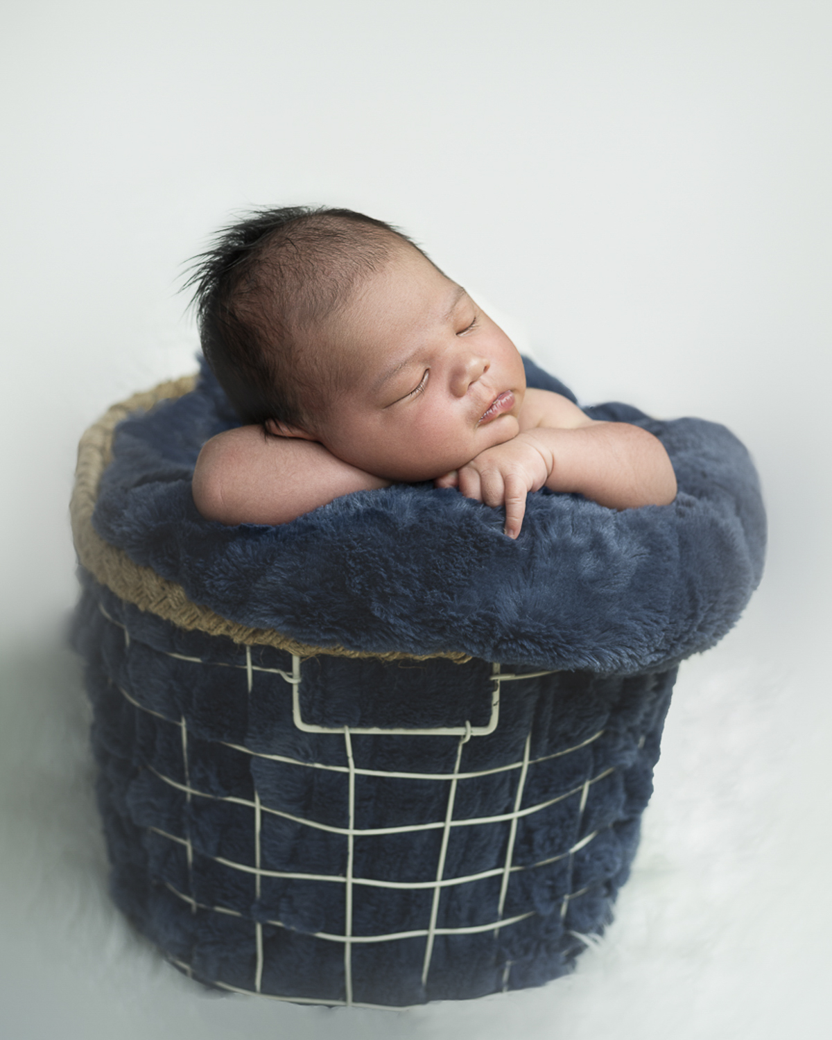 Newborn boy basket pose by NP Photography