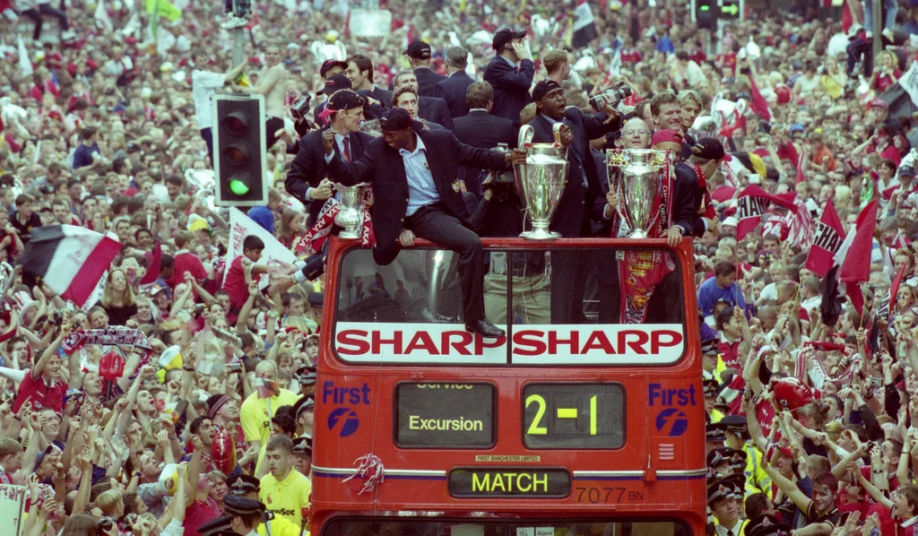 The champions celebrate their treble on the streets of Manchester.