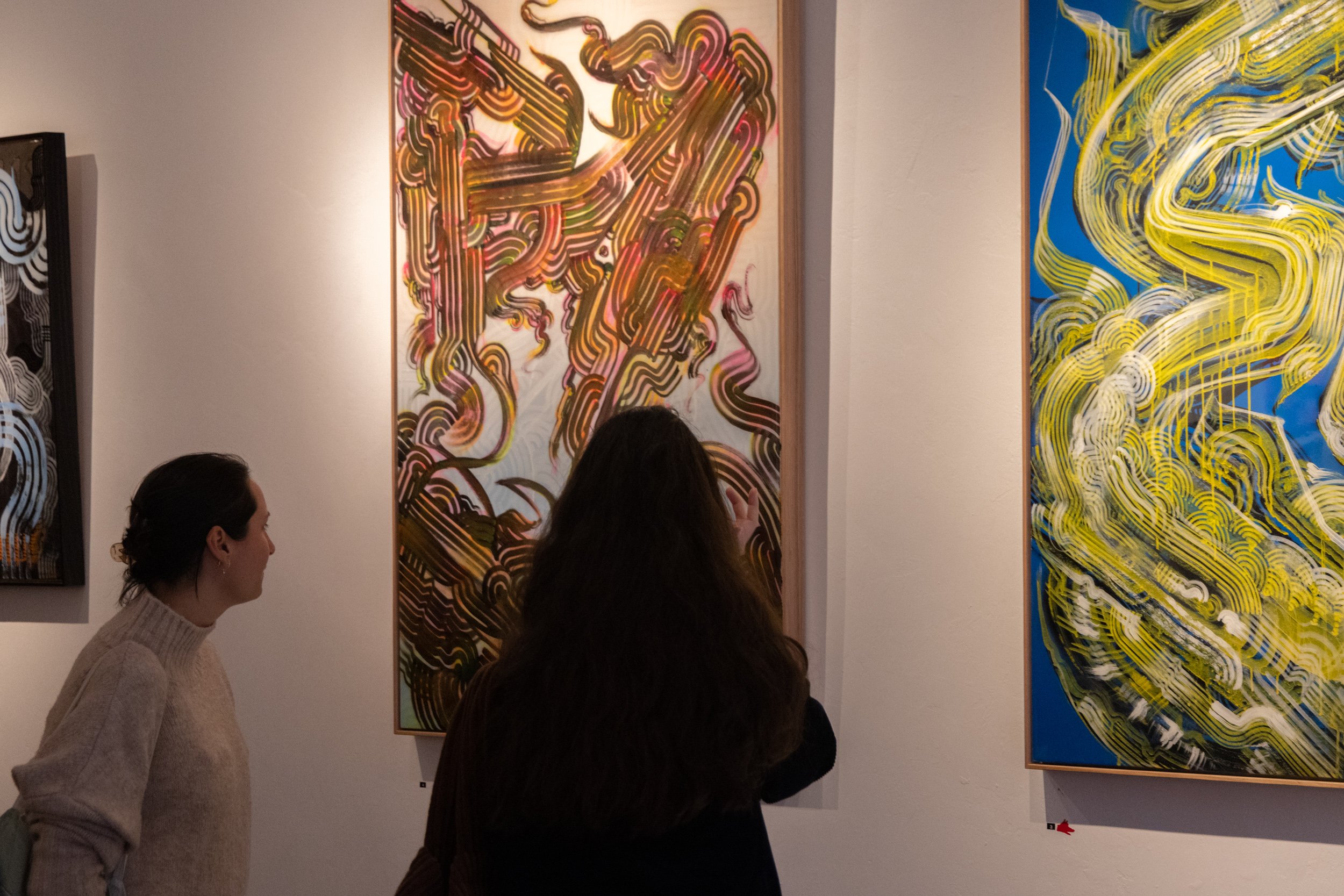 Photograph of visitor viewing artwork created by Bailer at Let's Pretend Gallery. The image is from Melbourne Graffiti Artist Bailer's opening night for their solo exhibition titled 'Mixed Messages'.
