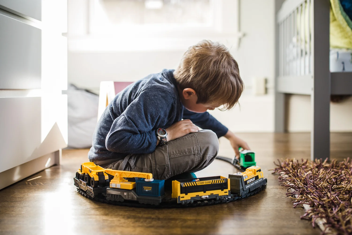 boy sitting inside tracks while driving trains - oakland child photographer