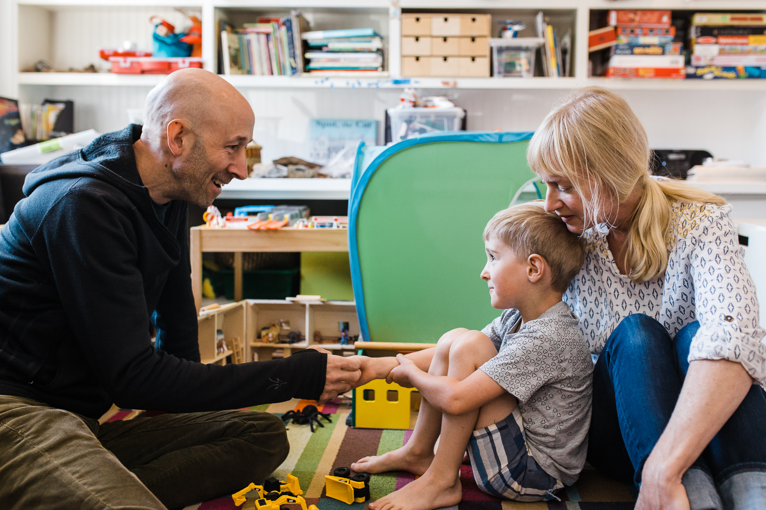 five year old boy playing with his parents on the floor {San Francisco in-home Family Photographer}