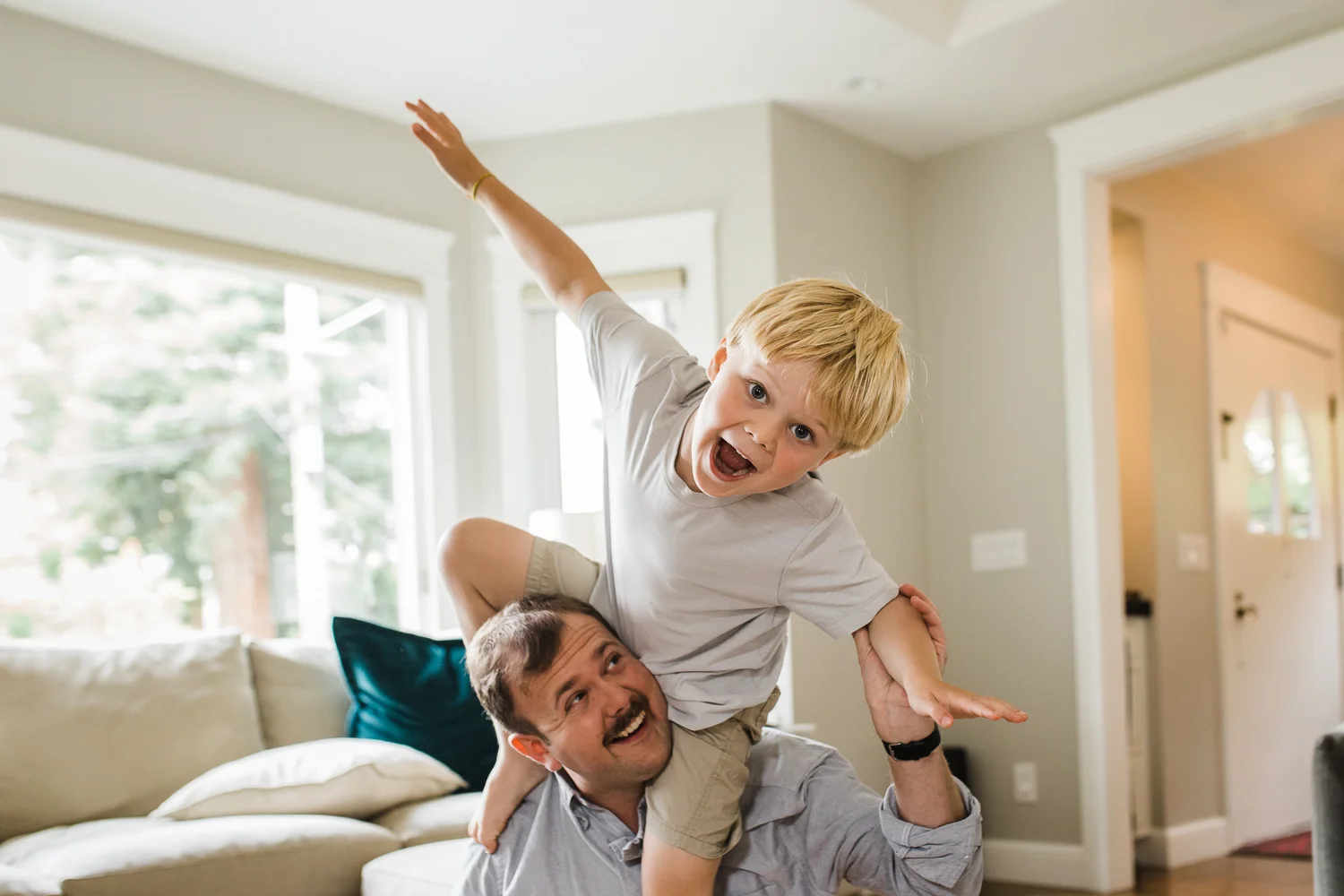 a 5 year old boy smiling and climbing on top of his dad's shoulders {East Bay in-homr lifestyle Family Photography}