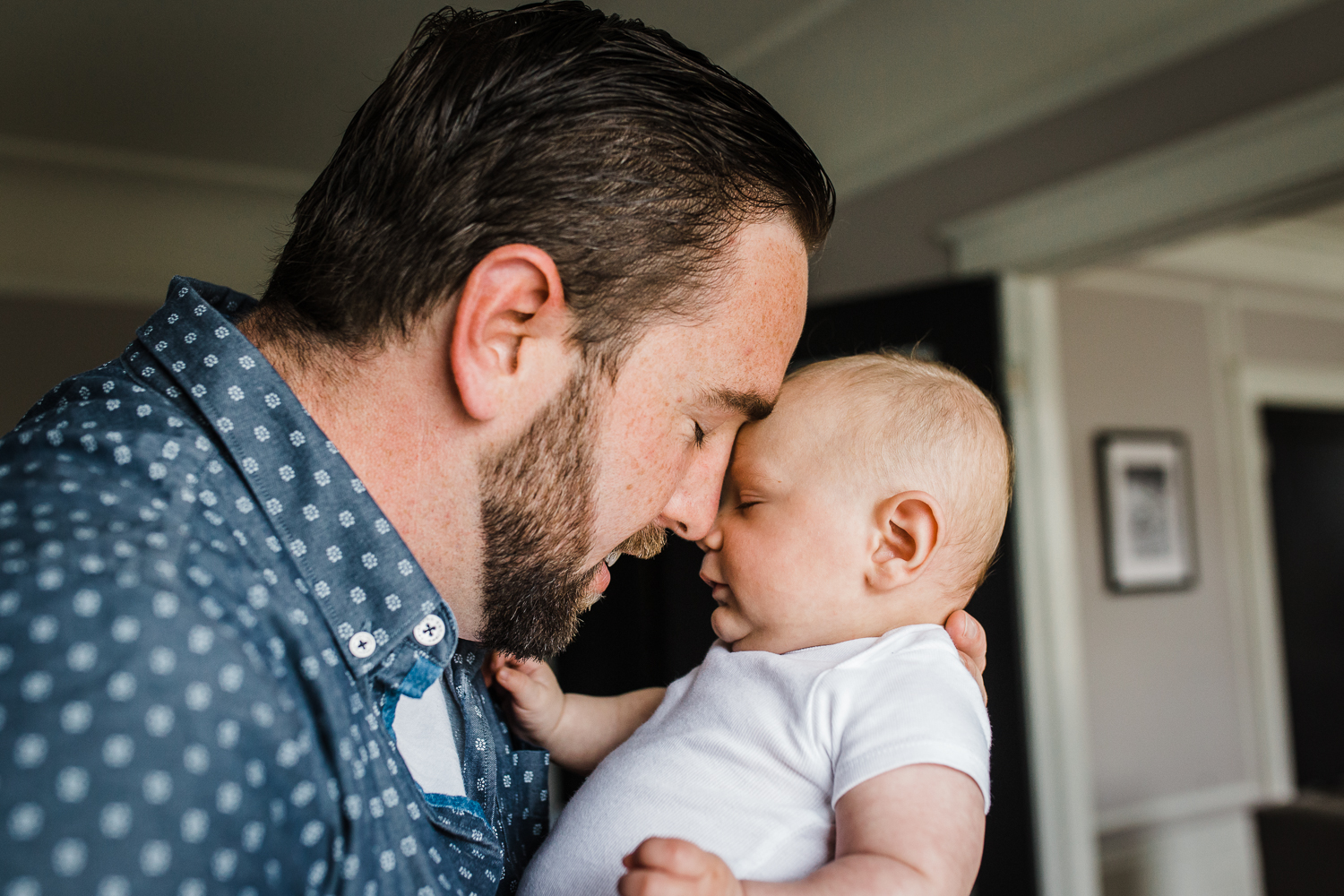 candid moment - Dad with his face close to and snuggling his newborn baby boy {San Francisco in-home lifestyle newborn photographer}