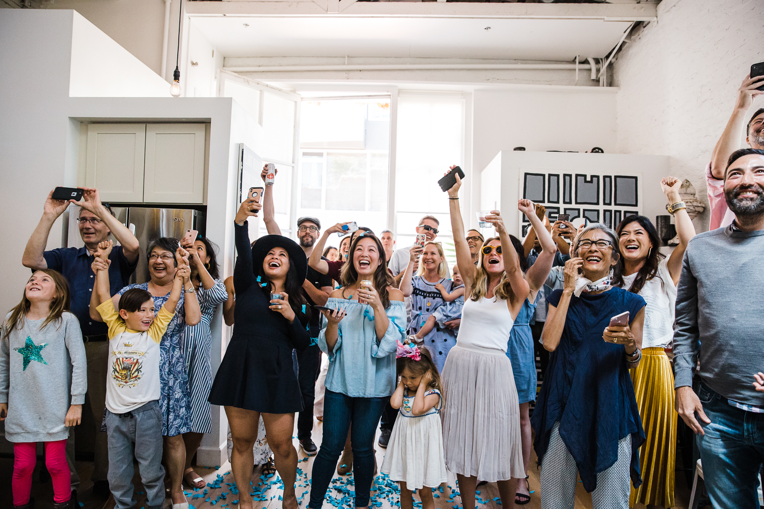 Excited family and friends celebrating when they find out it’s a boy at a gender reveal party {San Francisco Newborn Photographer}