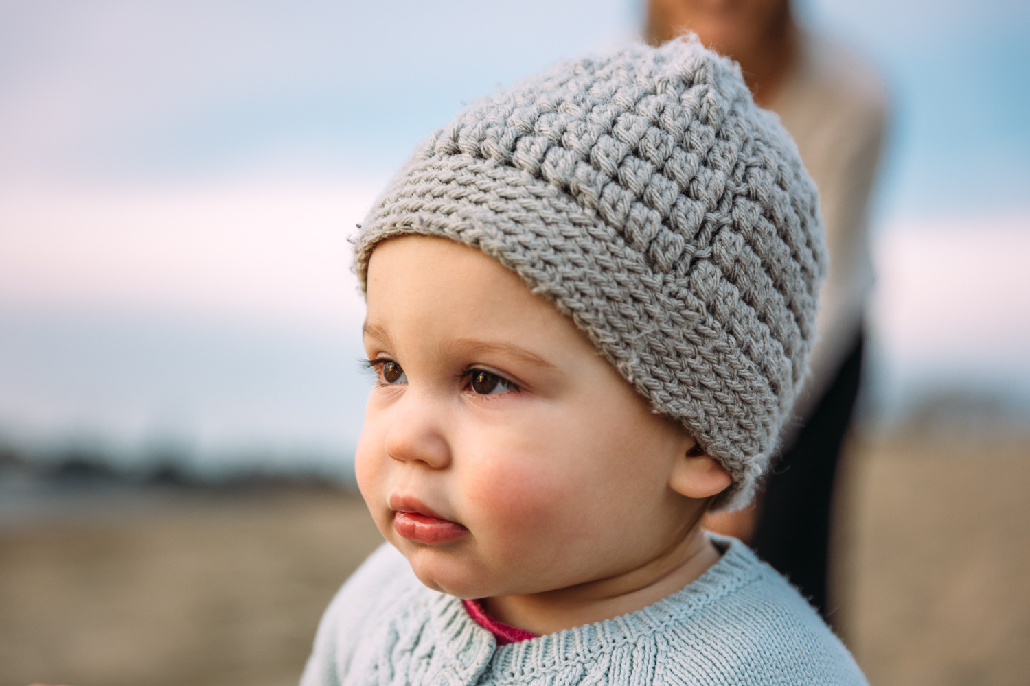portrait of a one year oldbaby with her hat on on the beach {East Bay Baby Photographer}