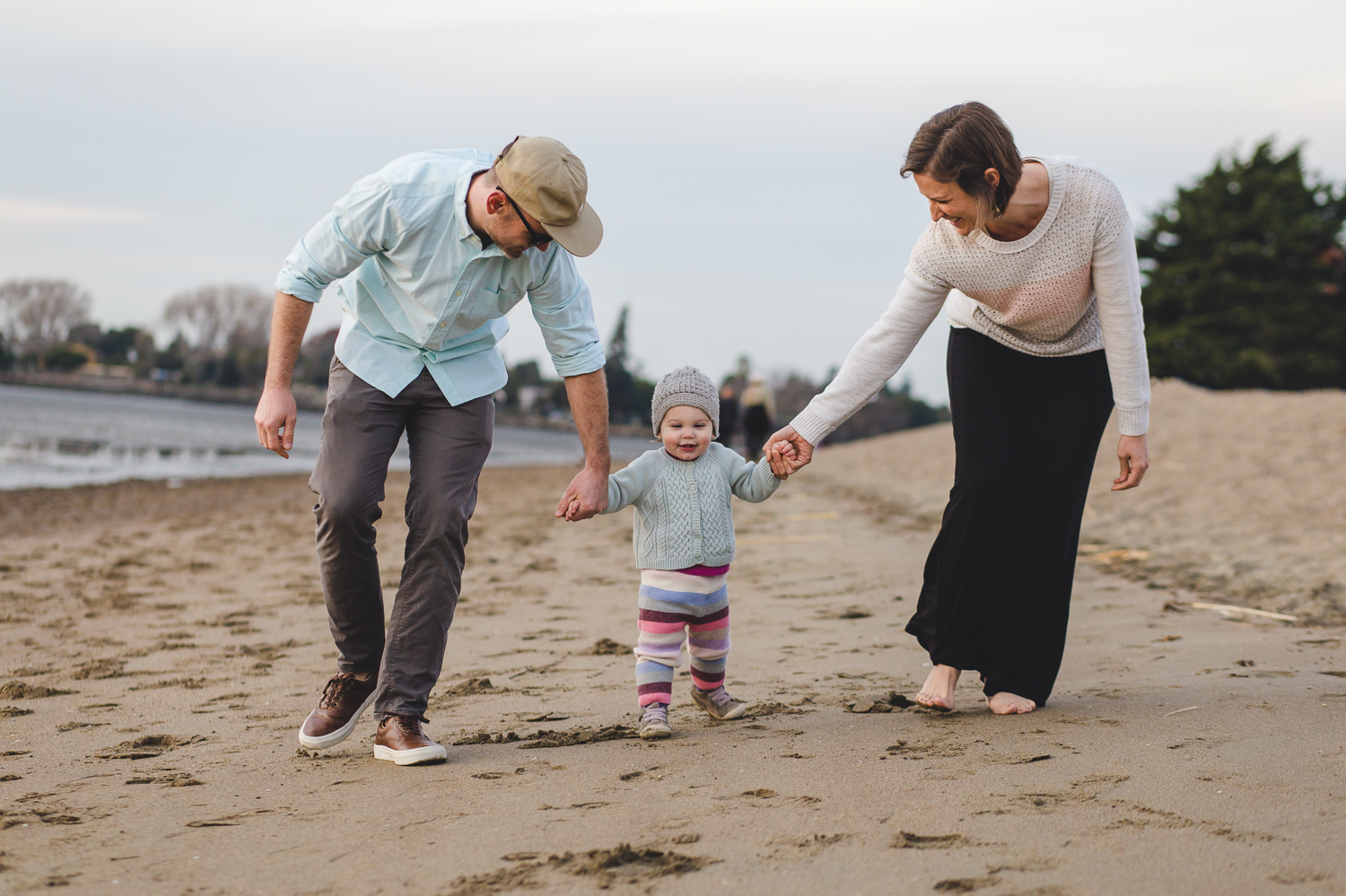 family of three all holding hands and walking down the beach {East Bay Family Photographer}