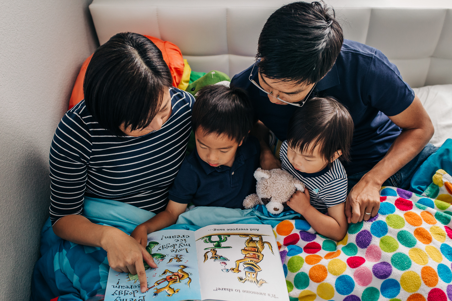 birds eye view of a family reading a book together in bed | East Bay Lifestyle Family Photographer