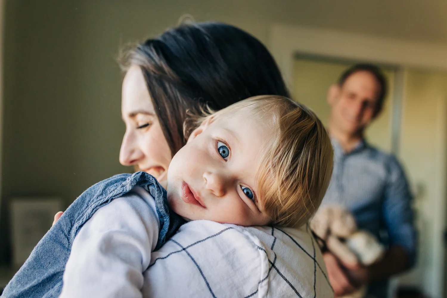 one year old girl resting her head on her mom's shoulder and looking at the camera | San Francisco Baby Photographer