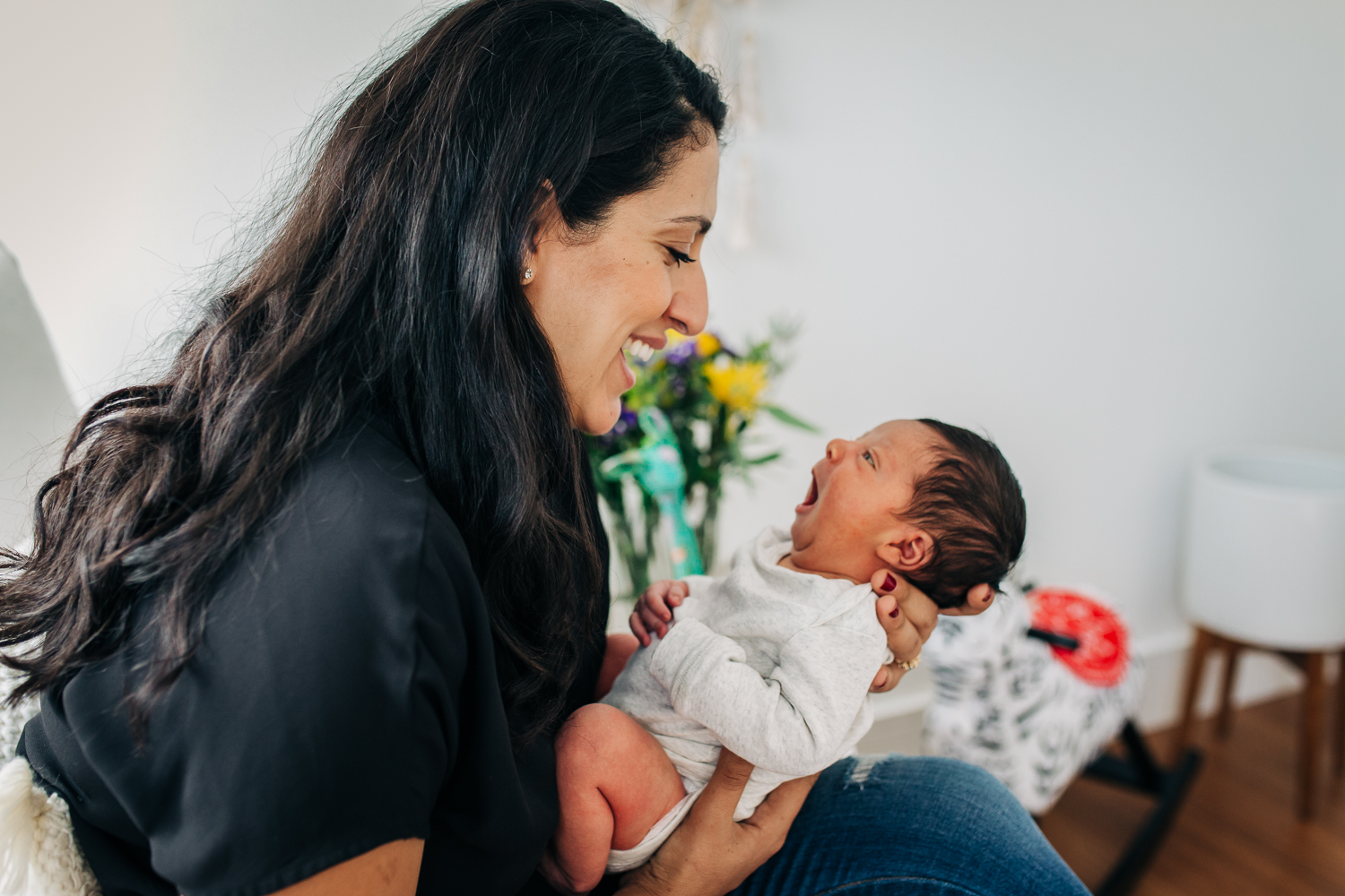 Mom holding her newborn baby close and smiling as they gaze at each other | San Francisco Family Photographer