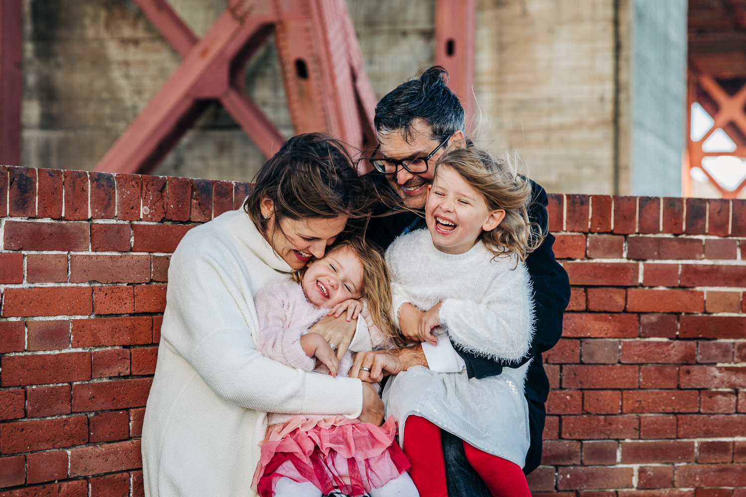 Family of four snuggling in close and laughing on a windy day {San Francisco Family Photography}