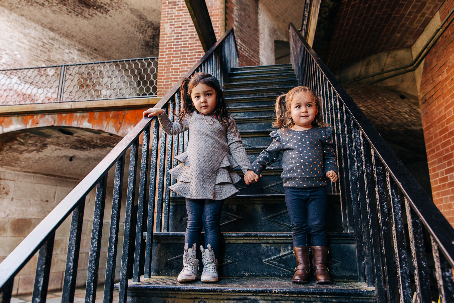 Two sisters standing on stairs and holding hands {SF Family Photographer}
