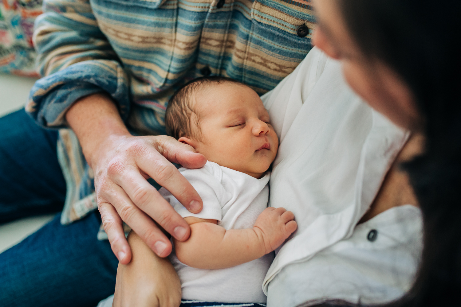 Mother holding baby boy with Dad's hand resting on his shoulder while he sleeps | San Francisco Newborn Photographer