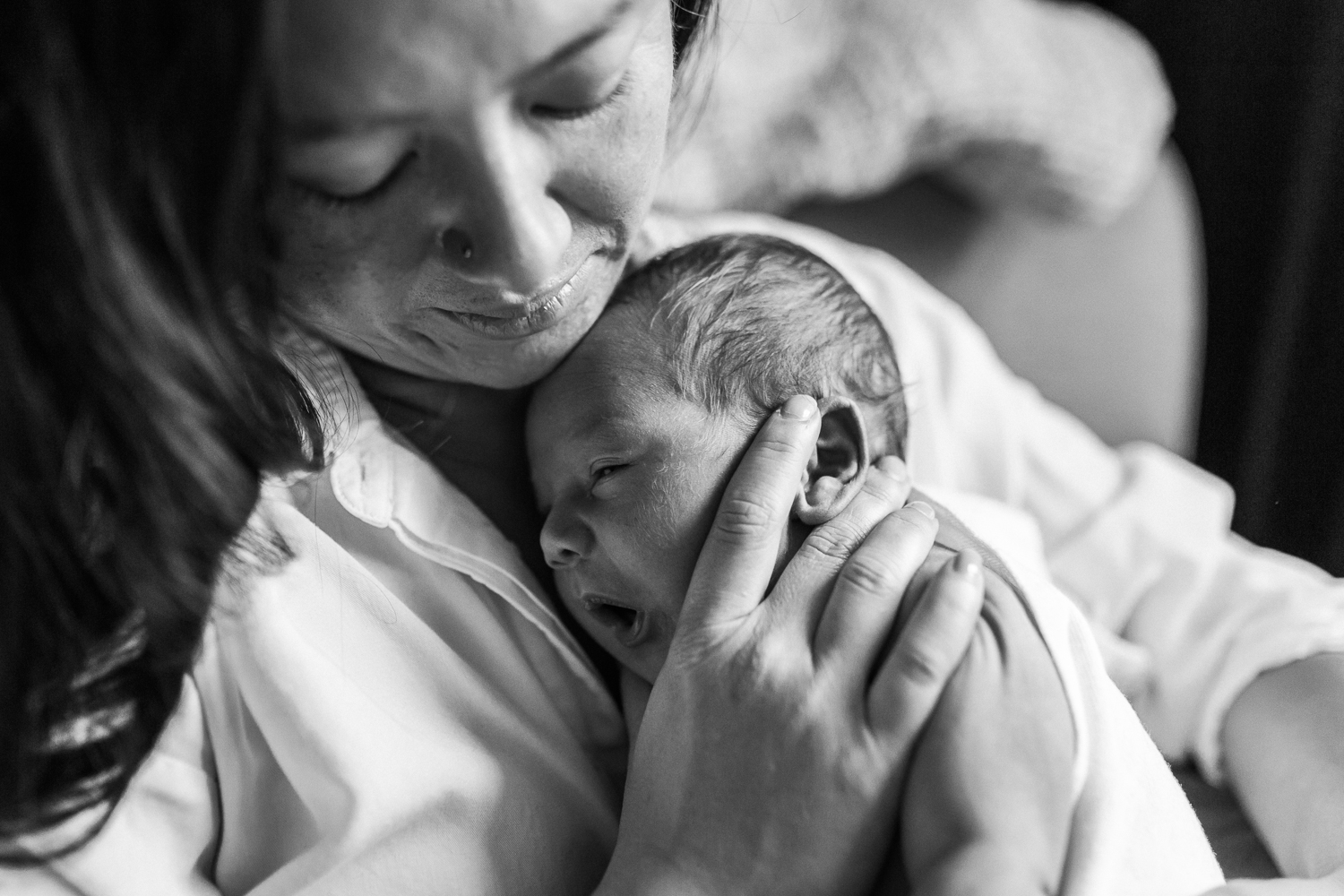 Mother supporting her baby boy's head and snuggling in close to him | East Bay Newborn Photographer