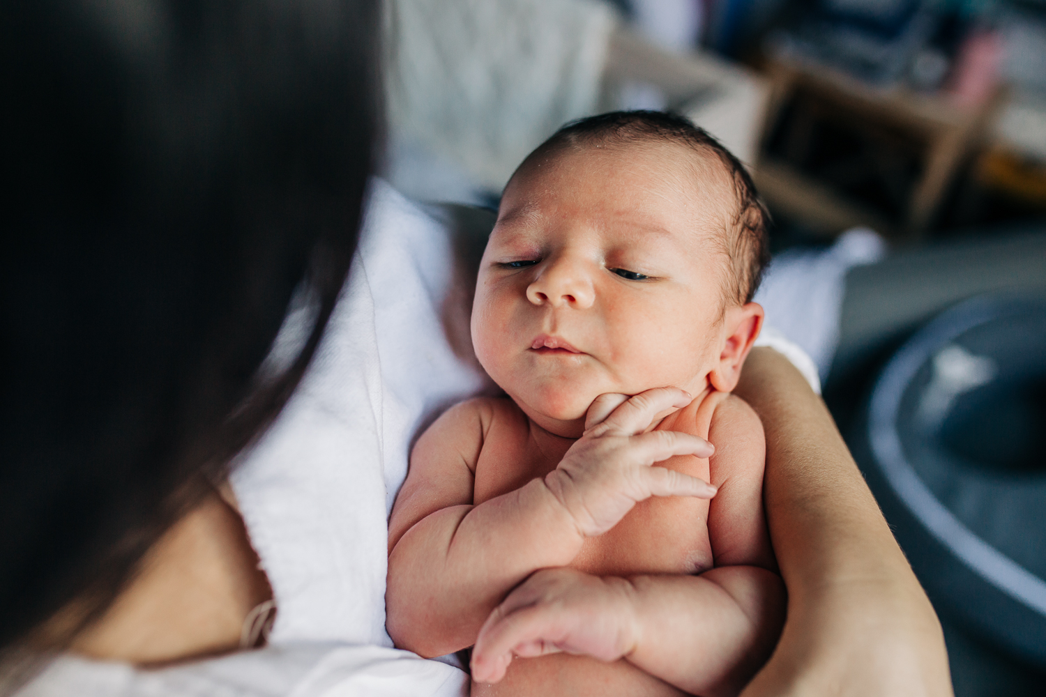 close up of a one week old boy sleeping in his Mom's arms with no clothes on | Oakland Newborn Photographer