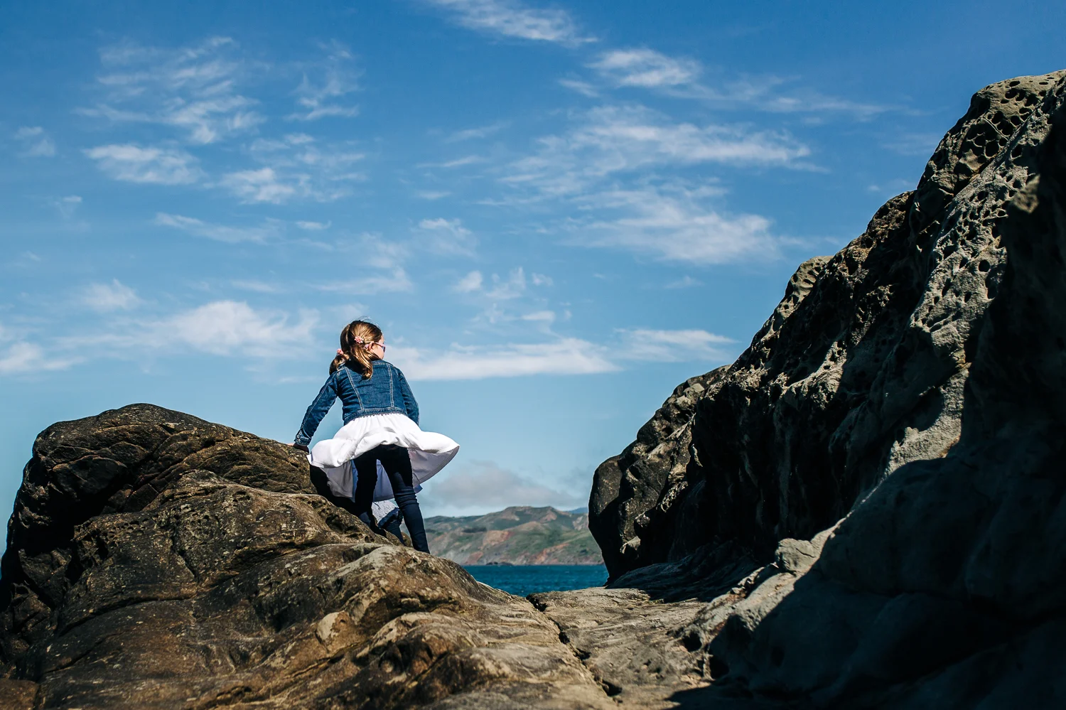 girl standing on a rock looking out at the pacific ocean - san francisco child photographer