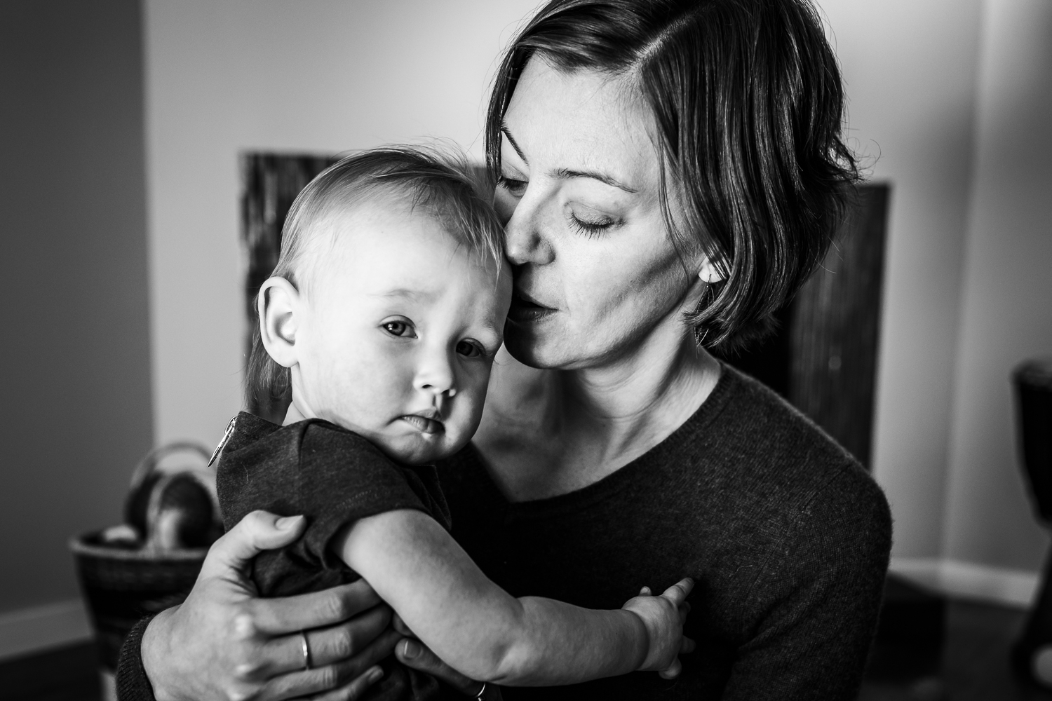 baby is looking at the camera while mom holds her close | San Francisco Family Photographer