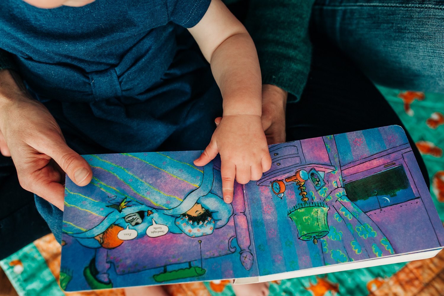 Hands of baby girl pointing at pages in a book | San Francisco Family Photographer