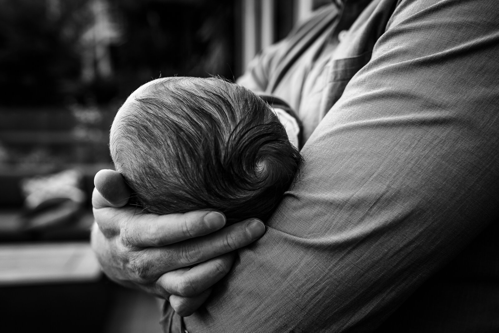 dad cradling baby boy in his arm and holding his head with the other hand - Oakland Newborn Photographer