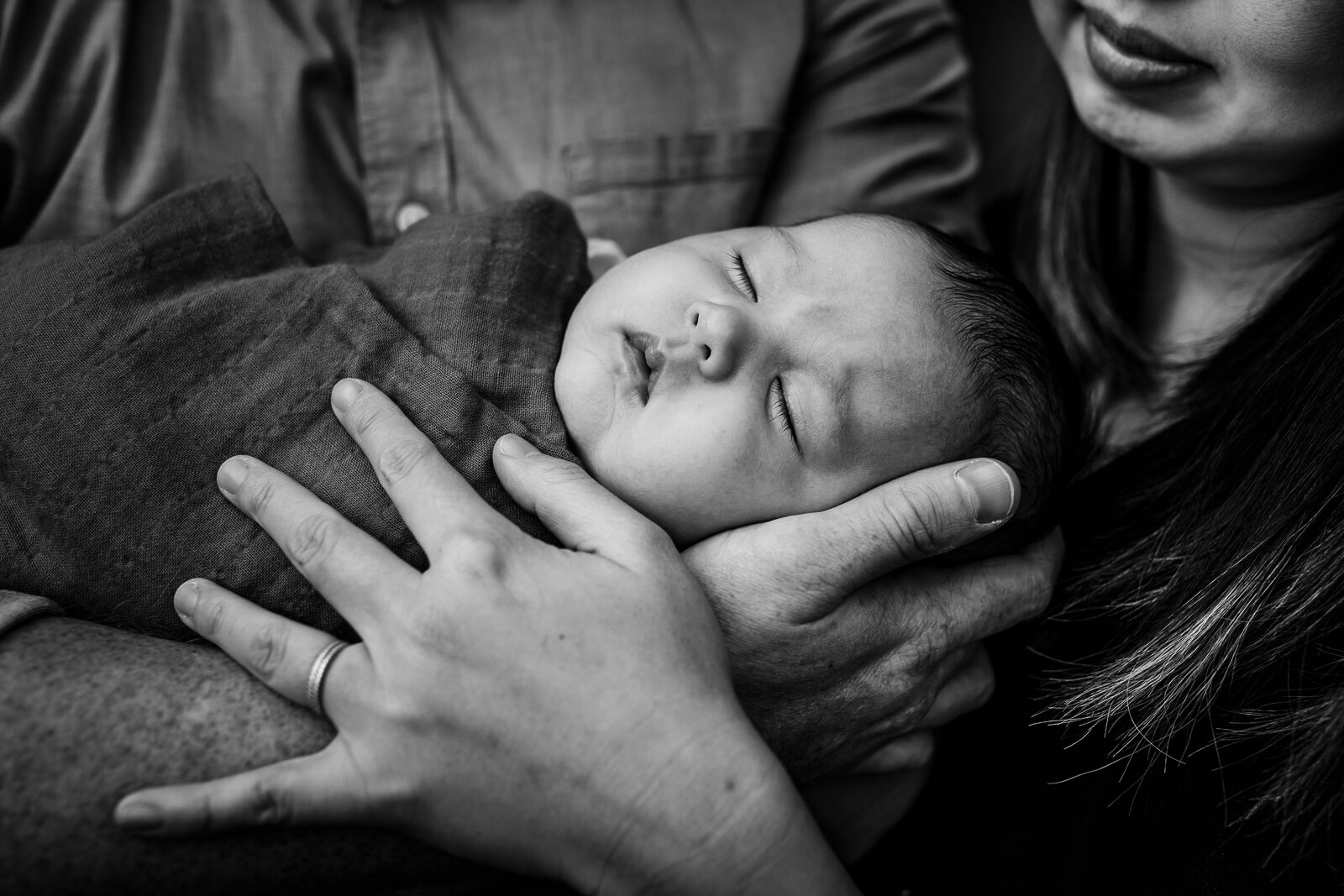 portrait of baby sleeping in mom and dad's arms - Bay Area Newborn Photographer