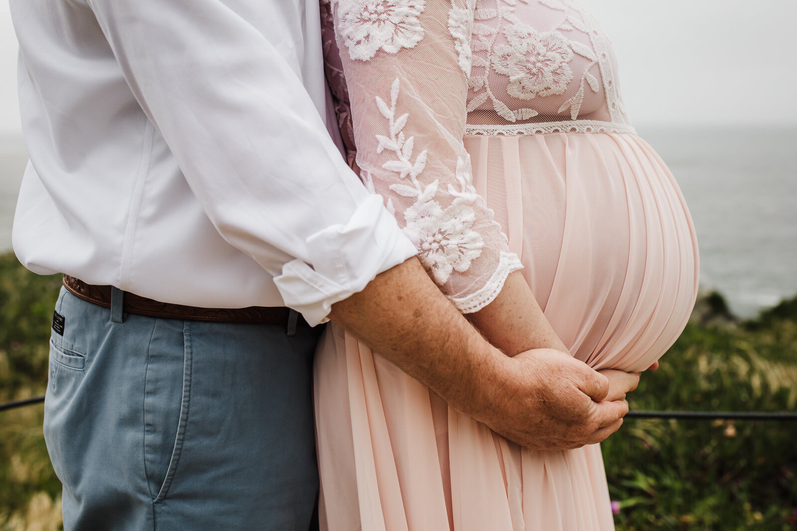 partner and wife holding hands and embracing pregnant belly - San Francisco Maternity Photographer