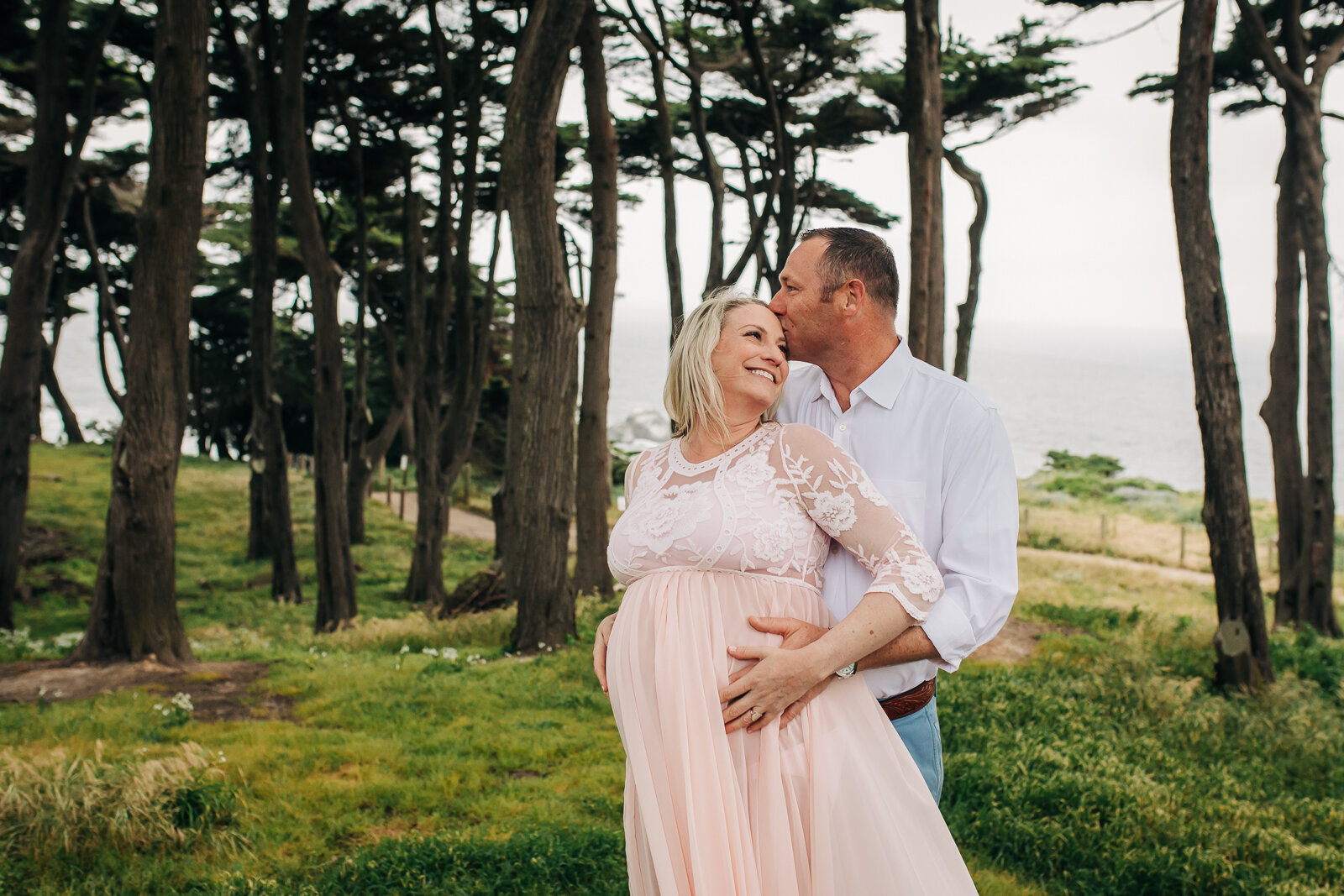 partner embracing and kissing pregnant wife - San Francisco Maternity Photographer