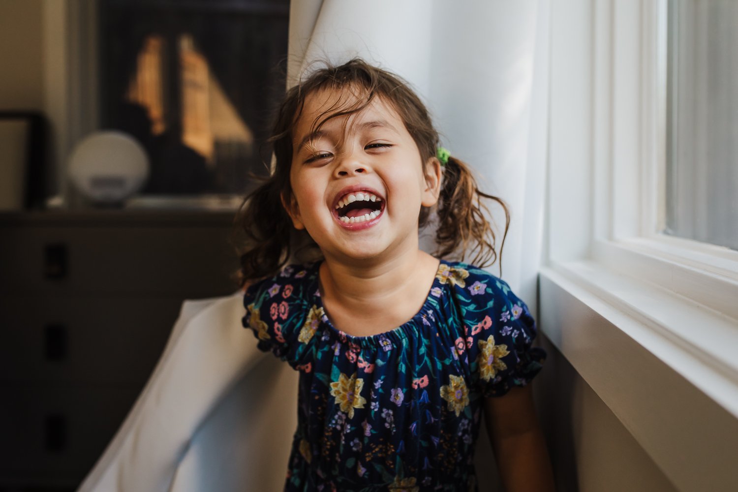 san-francisco-family-photographer-girl-laughing-by-window.jpg