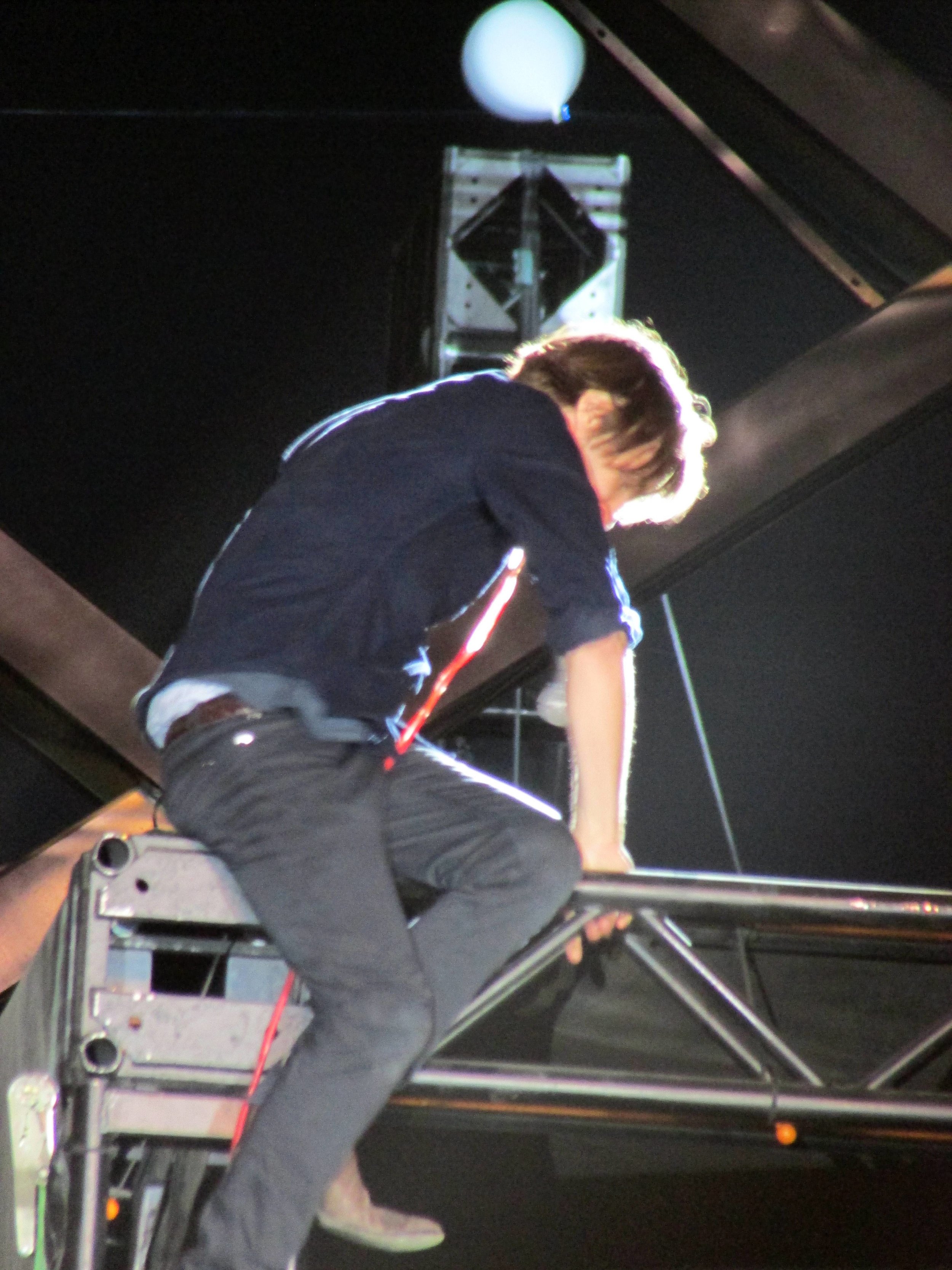 14 - Lead singer of Phoenix, Thomas Mars, climbing up a lighting rig in the middle of the crowd.JPG