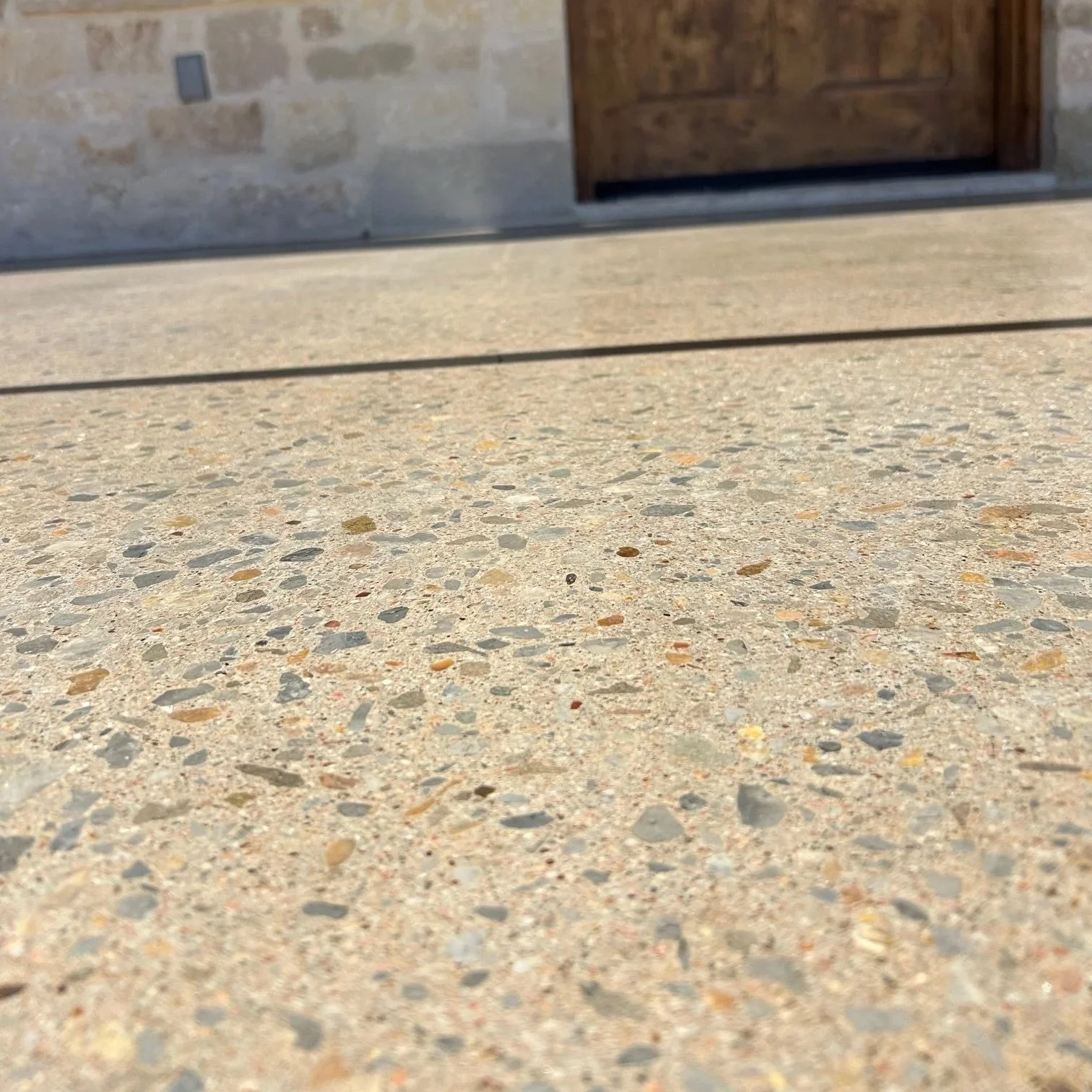 A close up of exposed aggregate concrete that has been polished and sealed.