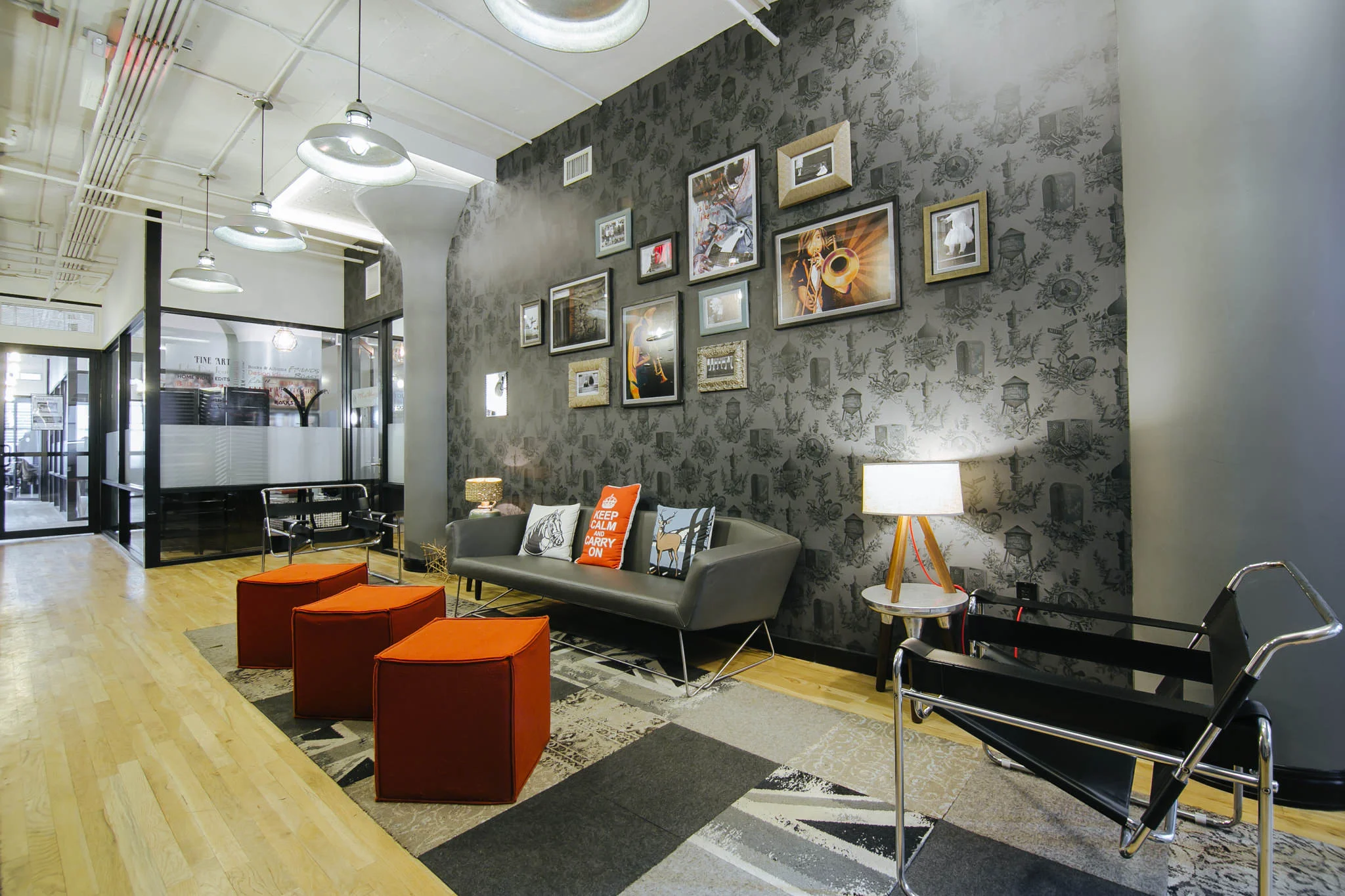 Lounge area with Victorian-esque wallpaper and bright orange seating in WeWork on Varick Street, New York. MEP designs by 2L Engineering.