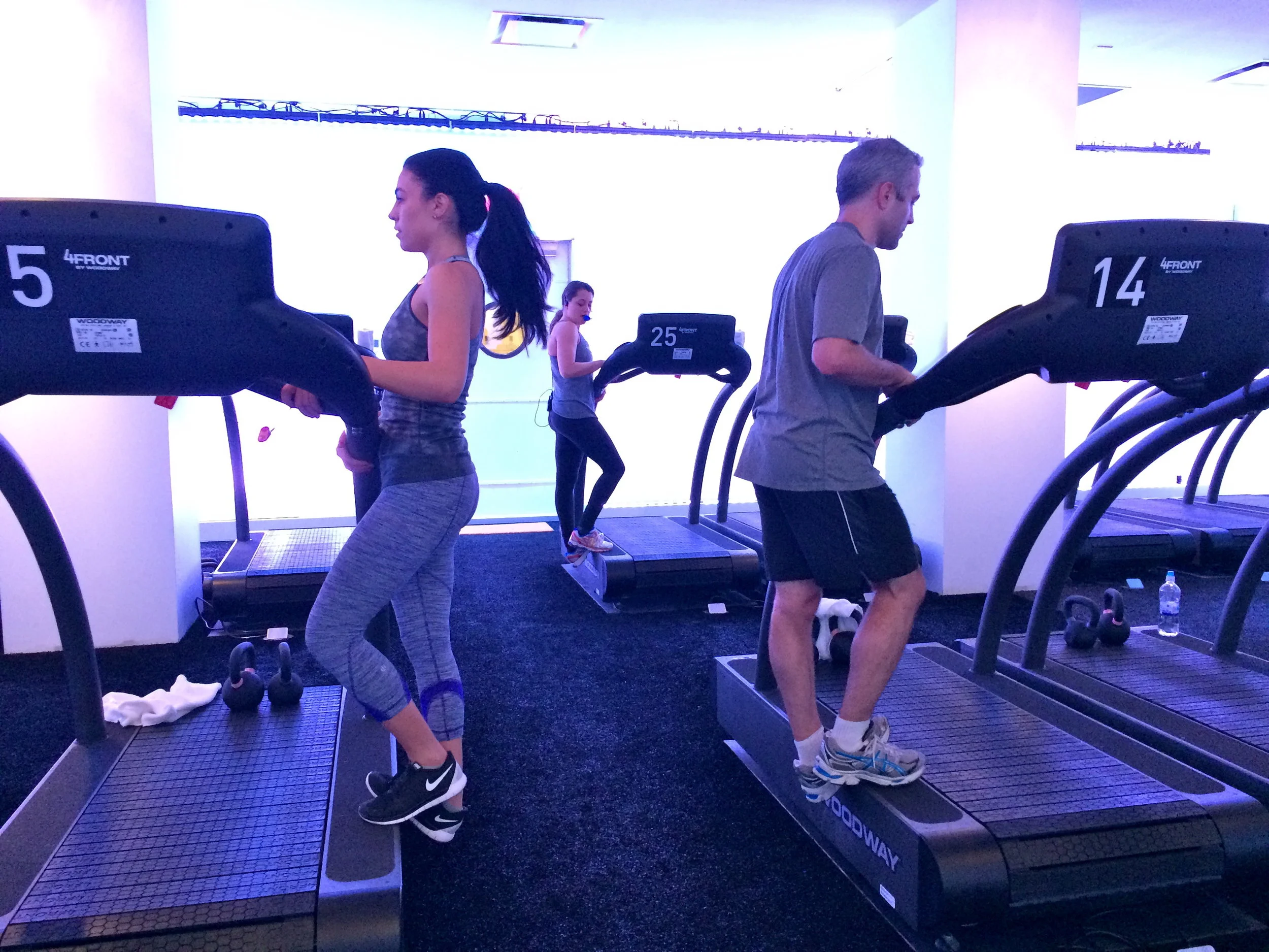Runners stretching their legs guided by an instructor at a running studio of the Mile High Run Club in New York with MEP design provided by 2L Engineering.