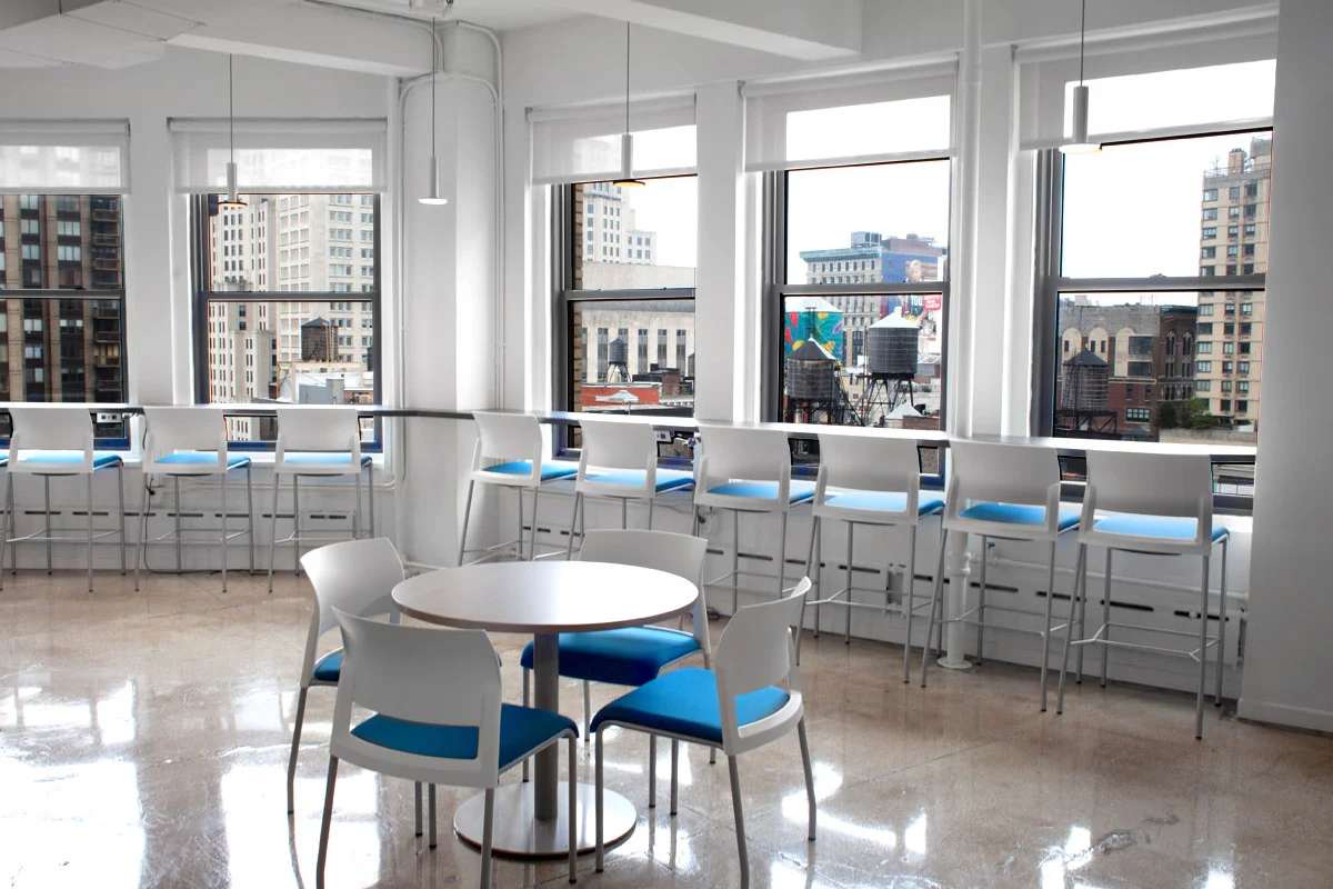 Blue and white chairs in Publishers Clearing House office's lounge area facing the New York City skyline. MEP provided by 2L Engineering.