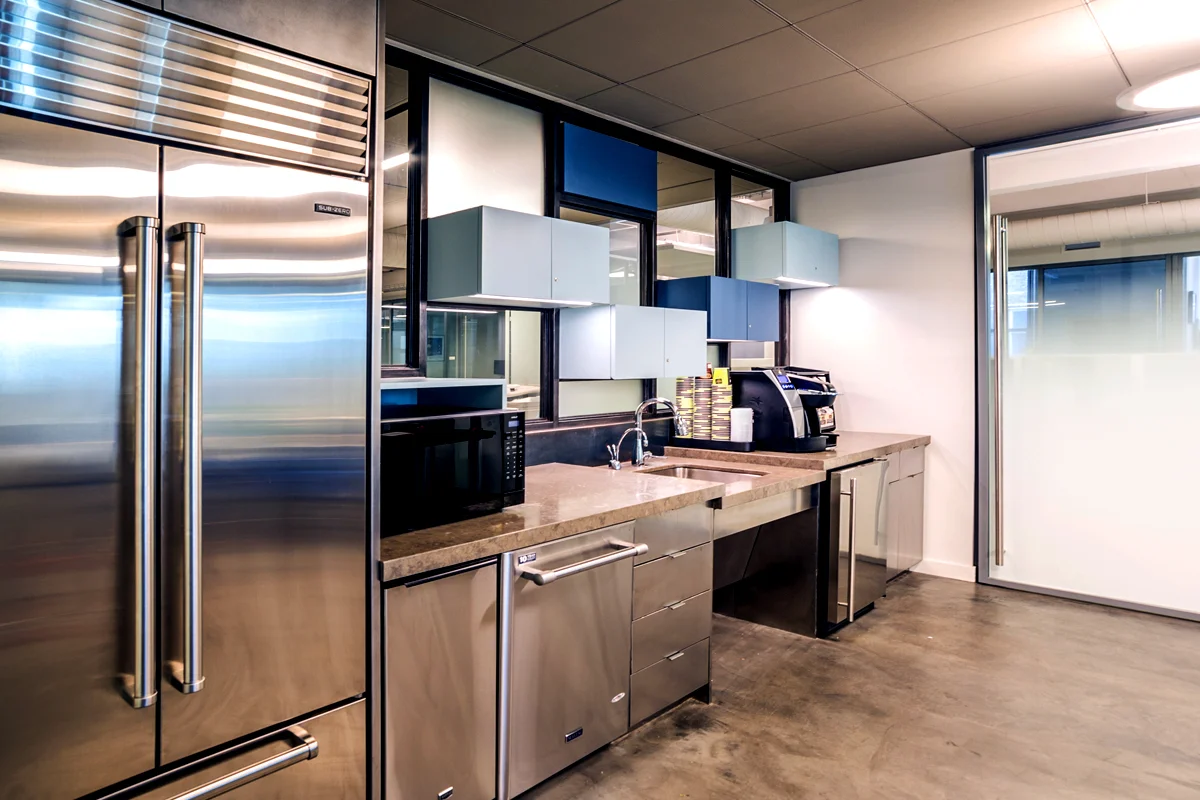 Kitchenette designed with hovering cabinets in different shades of blue in the offices of Rockrose. MEP designed by 2L Engineering.
