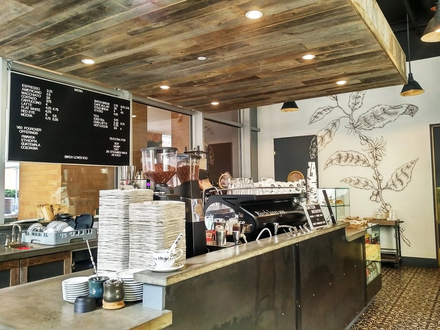Counter where the baristas work in front of a menu in Birch Coffee, a cafe with MEP designed by 2L Engineering.
