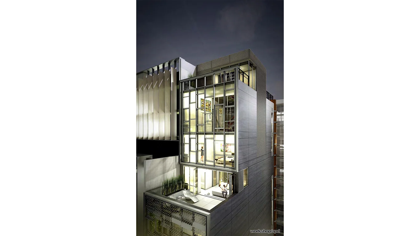 Nighttime view of the balcony of Casa Moderne, with the interior of the building lit up and a person lounging on a bed. MEP provided by 2L Engineering.