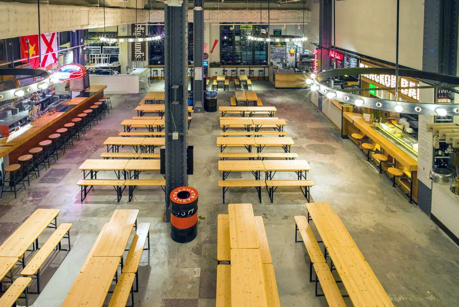 View of the eating area surrounded by food vendors in Urbanspace Vanderbilt, a food hall located near Grand Central Terminal. MEP designed by 2L Engineering.