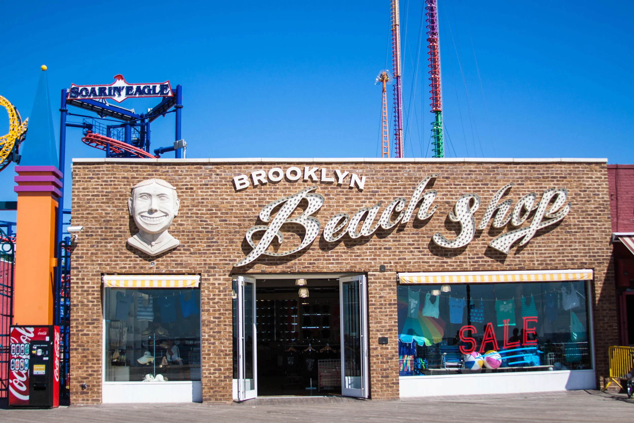 Brooklyn Beach shop exterior facade with inlaid brick and the famous Face of Steeplechase - the iconic Coney Island mascot - beside the store signage. MEP designed by 2L Engineering.