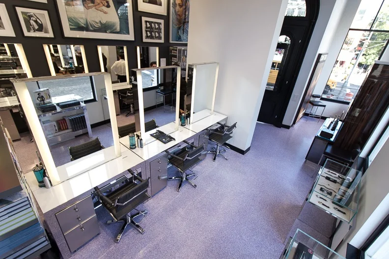 Beauty stations and an overhead view of display cases, photographs, and the entrance of John Barrett Salon in New York. MEP provided by 2L Engineering.