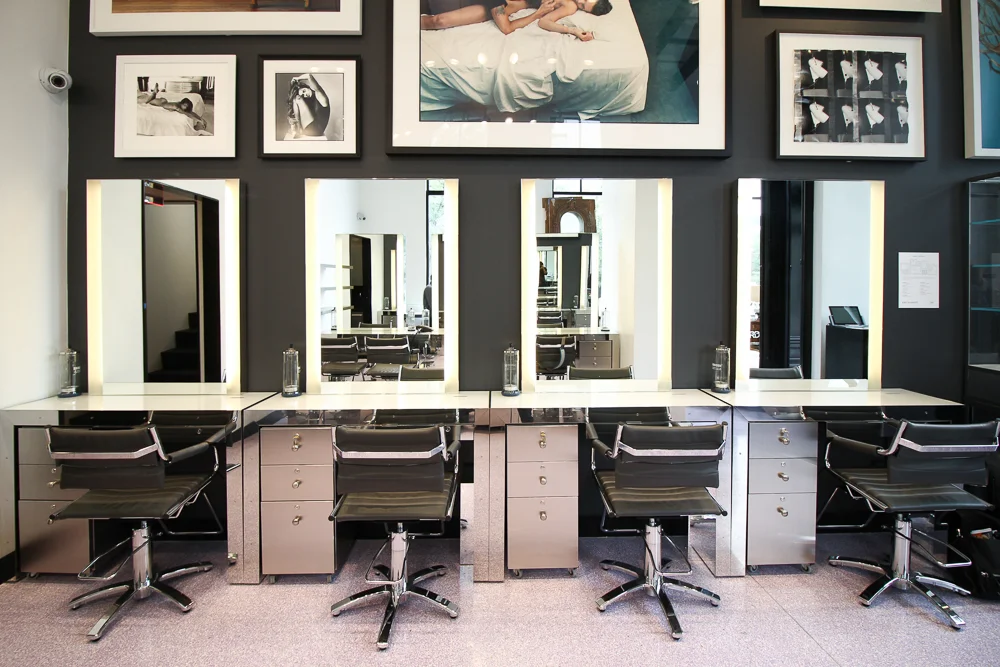 Beauty stations with bright mirrors and photographs displayed higher on the dark grey wall. MEP designed by 2L Engineering.