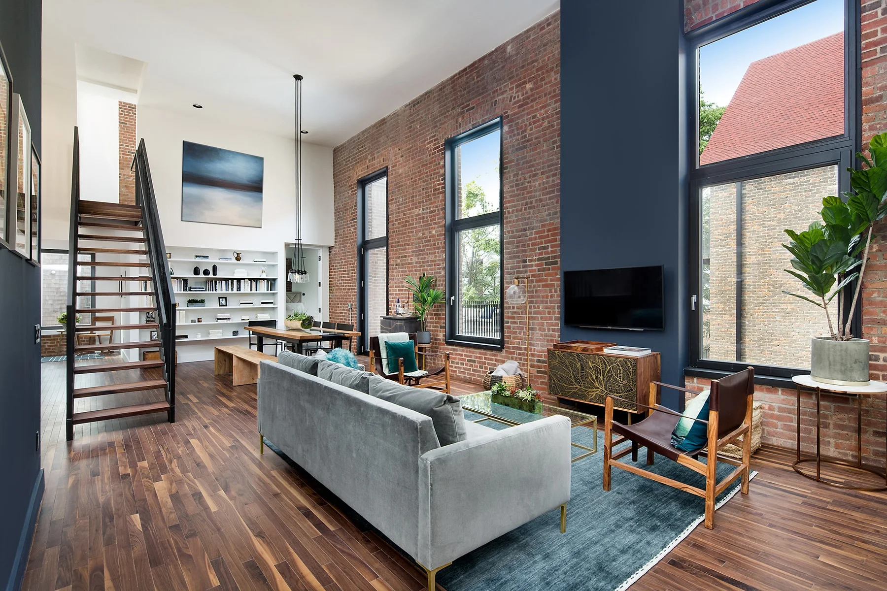 Living room with rustic interior design and stairs leading to the upper landing in a residential building in Brooklyn. MEP designed by 2L Engineering.